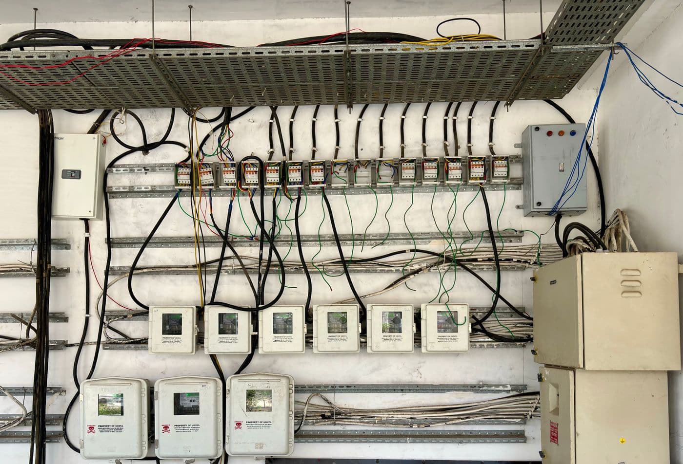Network of electrical wiring and control boxes on a wall